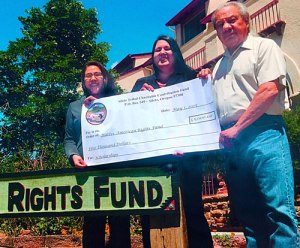 Alayna Farris, Whitney Gravelle, and John Echohawk recognize the donation from the Confederated Tribes of Siletz